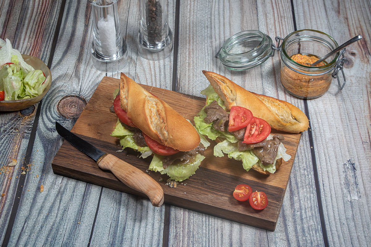 Bild eines Sandwichs mit Salat, Tomaten gebratenen Rindfleisch in Sauce